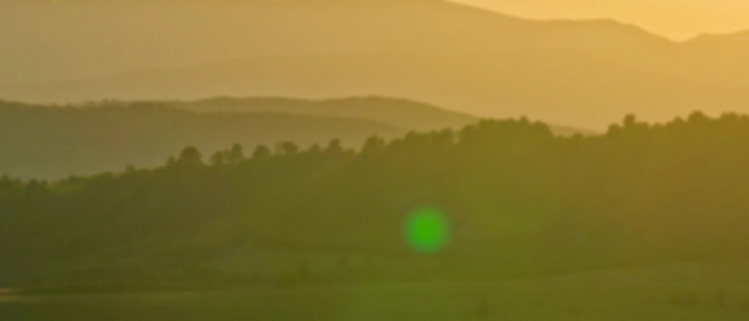 Soft focus background of rolling hills at sunset, warm amber light